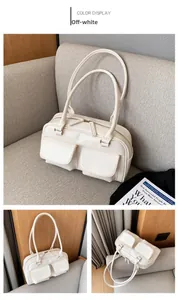 Detail view of off-white PU leather handbag featuring dual front pockets and long handles