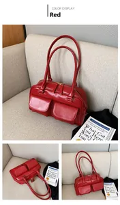 Detail view of a dark red leather handbag with dual handles and twin front flap pockets