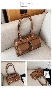Detail view of brown vintage leather handbag with dual front pockets and metallic buckles