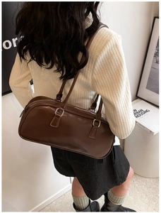 Close-up of brown vintage Boston bag showing silver double zipper and sleek PU leather