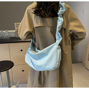 Rear view of a light blue pleated dumpling bag with a wide ruffled shoulder strap