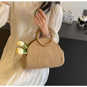 Détail du sac à main en paille tressé avec texture artisanale et poignée ronde