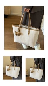 Detailed view of the ripple textured tote bag with brown leather trim and puppy charm