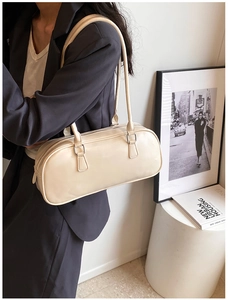 Detail of glossy beige Boston bag with polished surface and silver-tone hardware
