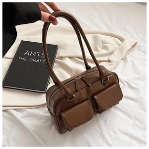 Detail of dark brown vintage Boston bag with dual handles and functional front flap pockets