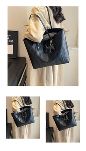 Close-up of black leather tote bag with wavy texture and cute dog charm attachment