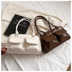 Minimalist matte leather tote bags in cream and dark coffee displayed on white linen
