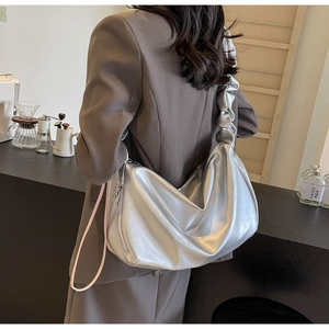Silver pleated tote bag detail showing large capacity and metallic texture on shoulder