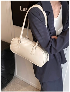 Close-up of beige leather Boston bag with silver hardware on a professional model