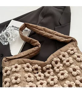 Detail of brown quilted tote bag with intricate two-tone 3D crochet flower decorations