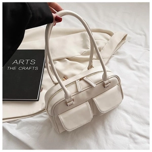 Detail of off-white Boston handbag with dual front pockets and top metal zipper