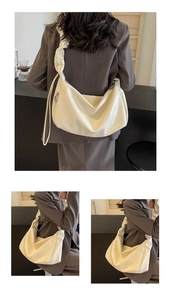 Detail of soft cream pleated cloud bag with oversized shoulder strap and crescent shape
