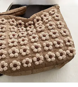 Close-up of brown quilted tote bag featuring exquisite handmade 3D crochet flower details
