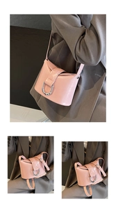Detail of pink leather bucket bag with silver U-shaped buckle and adjustable strap