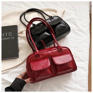 Detail view of red and black vintage Boston handbags in glossy leather with double front pockets