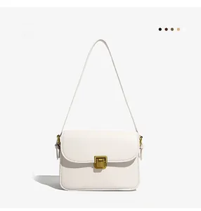 Detail of white rectangular leather shoulder bag featuring a vintage gold square lock clasp