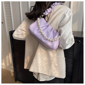 Detail of purple cloud bag featuring ruched texture and elegant pearl chain handle