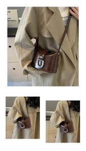 Detail of dark brown glossy leather bucket bag featuring a silver D-shaped buckle