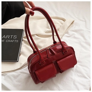 Detail view of retro red leather tote bag with double front pockets and metal zippers
