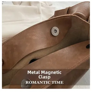 Détail du fermoir magnétique en métal sur un sac seau vintage en cuir marron texturé