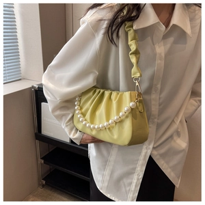 Detail of light green pleated cloud bag with white pearl chain and soft scrunched strap