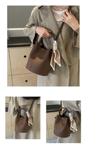 Detailed view of brown litchi leather bucket bag with fashion print silk scarf and strap