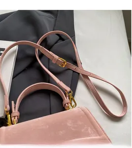 Détail du sac bandoulière rose avec sangle réglable et finitions métalliques dorées