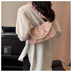Detail of pink ruched cloud bag featuring decorative pearl chain and matching wide strap