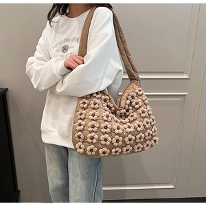 Detail of khaki quilted hobo bag with 3D crochet flowers and wide shoulder strap