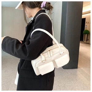 Chic cream leather shoulder bag with front flap pockets shown on black blazer model