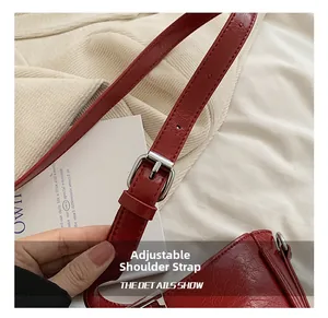 Détail du sac à bandoulière en cuir PU rouge avec boucle en métal argenté et texture froissée