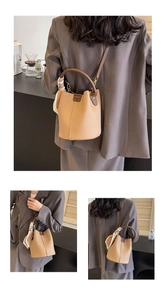 Detail view of khaki lychee leather bucket bag with silk scarf and adjustable strap