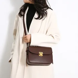 Classic dark brown leather crossbody bag with gold lock buckle and adjustable shoulder strap