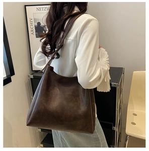 Détail d'un sac cabas en cuir marron vintage avec bandoulière réglable et grand volume