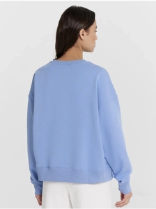Detail view of the back of a light blue crewneck sweatshirt with ribbed cuffs and hem