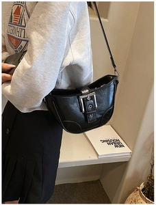 Détail d'un sac sous le bras noir vintage en forme de croissant avec boucle argentée