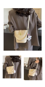 Detail of cream white bucket bag with smooth faux leather texture and star charm