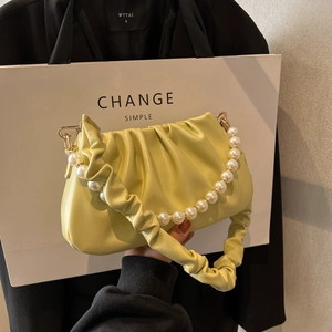 Pale yellow pleated cloud bag with pearl chain handle and soft leather texture