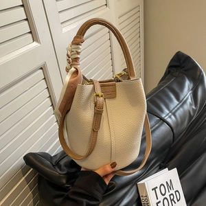 Litchi pattern bucket bag with brown handles and silk scarf detail on cream leather