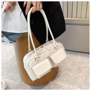Close-up of stylish cream PU leather handbag with dual front pockets and top handles