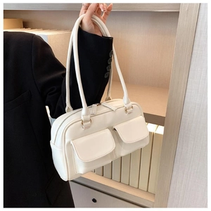 Detail of cream white PU leather handbag featuring dual front pockets and shoulder straps