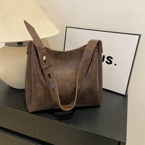 Sac hobo vintage marron avec large bandoulière dans un décor intérieur minimaliste