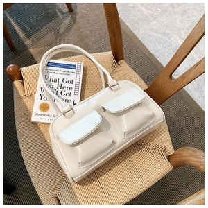 Chic cream white PU leather handbag featuring dual front pockets and top handle detail
