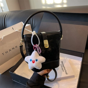 Chic black leather bucket bag with gold clasp and plush star charm in a luxury gift box