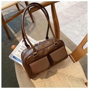 Detail shot of vintage brown leather shoulder bag with two magnetic flap front pockets