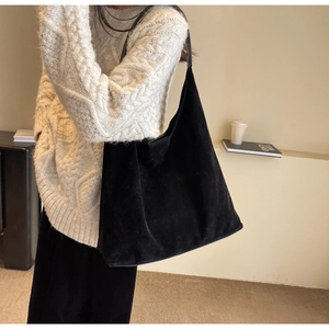 Close-up of black suede tote bag on shoulder, showcasing premium matte texture and minimalist design