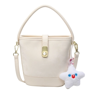 Minimalist beige suede bucket bag with gold clasp and star plush charm on white background