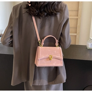 Détail du sac bandoulière rose en suédine avec boucle dorée et fine bandoulière