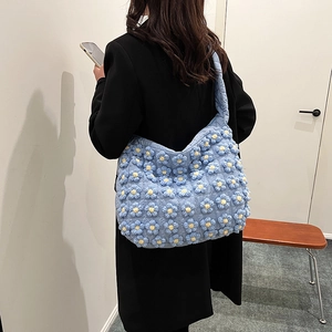 Light blue quilted cloud tote bag with 3D daisy flower decorations and wide shoulder strap