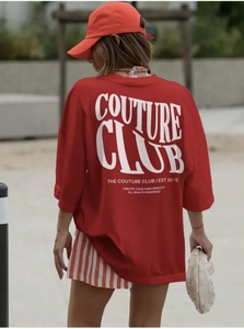 Detail of red oversized T-shirt with white COUTURE CLUB art print on the back